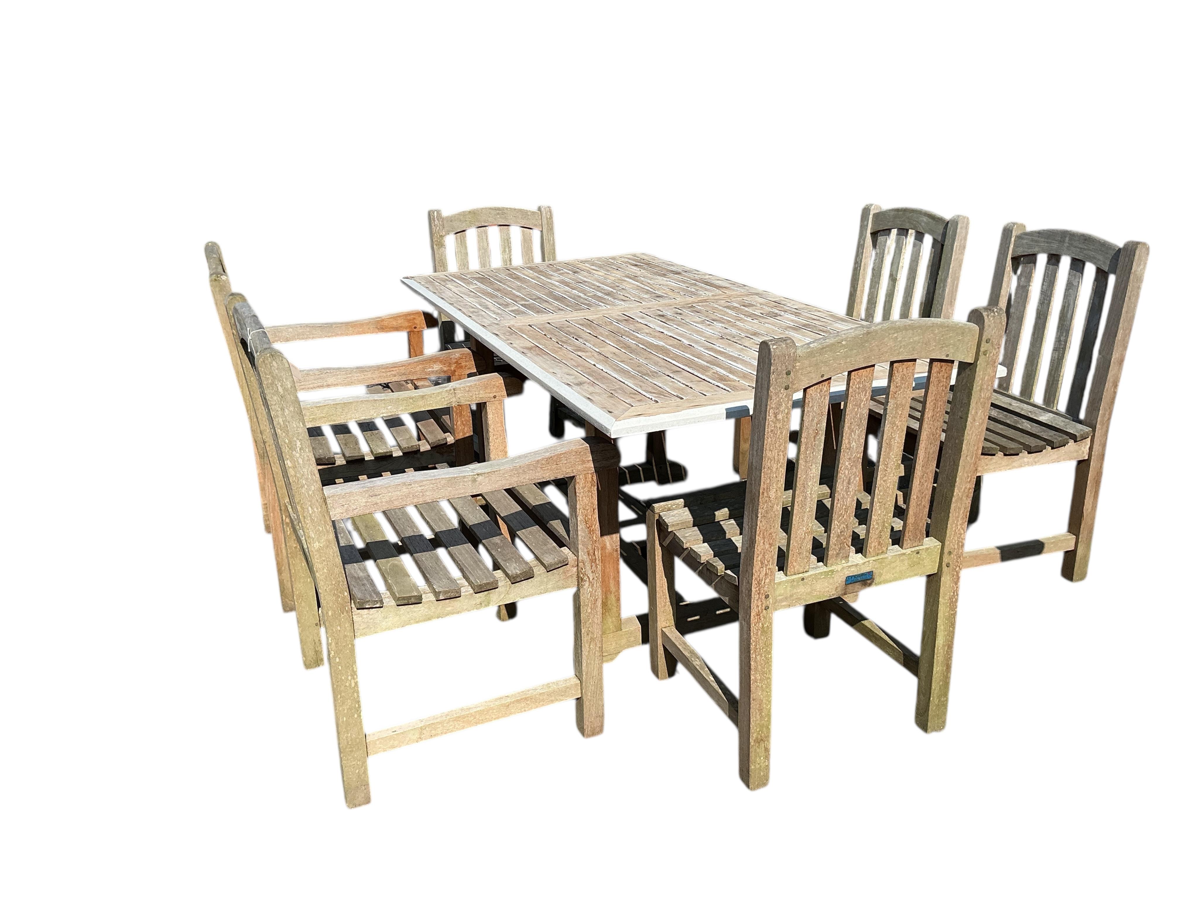 A rectangular weathered teak garden table, width 180cm, depth 90cm, height 75cm and six Lindsey weathered teak garden chairs, two with arms